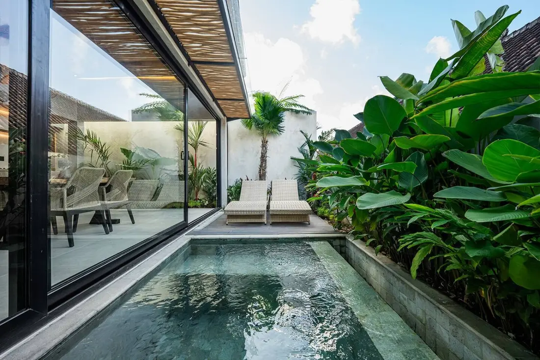 Private pool and loungers beside Ayla Villa's glass facade